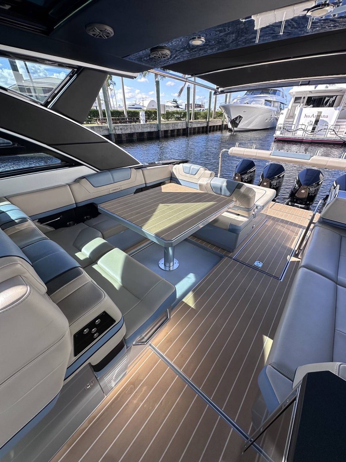Formula 430 SSC cockpit dining area with power lift table under hardtop