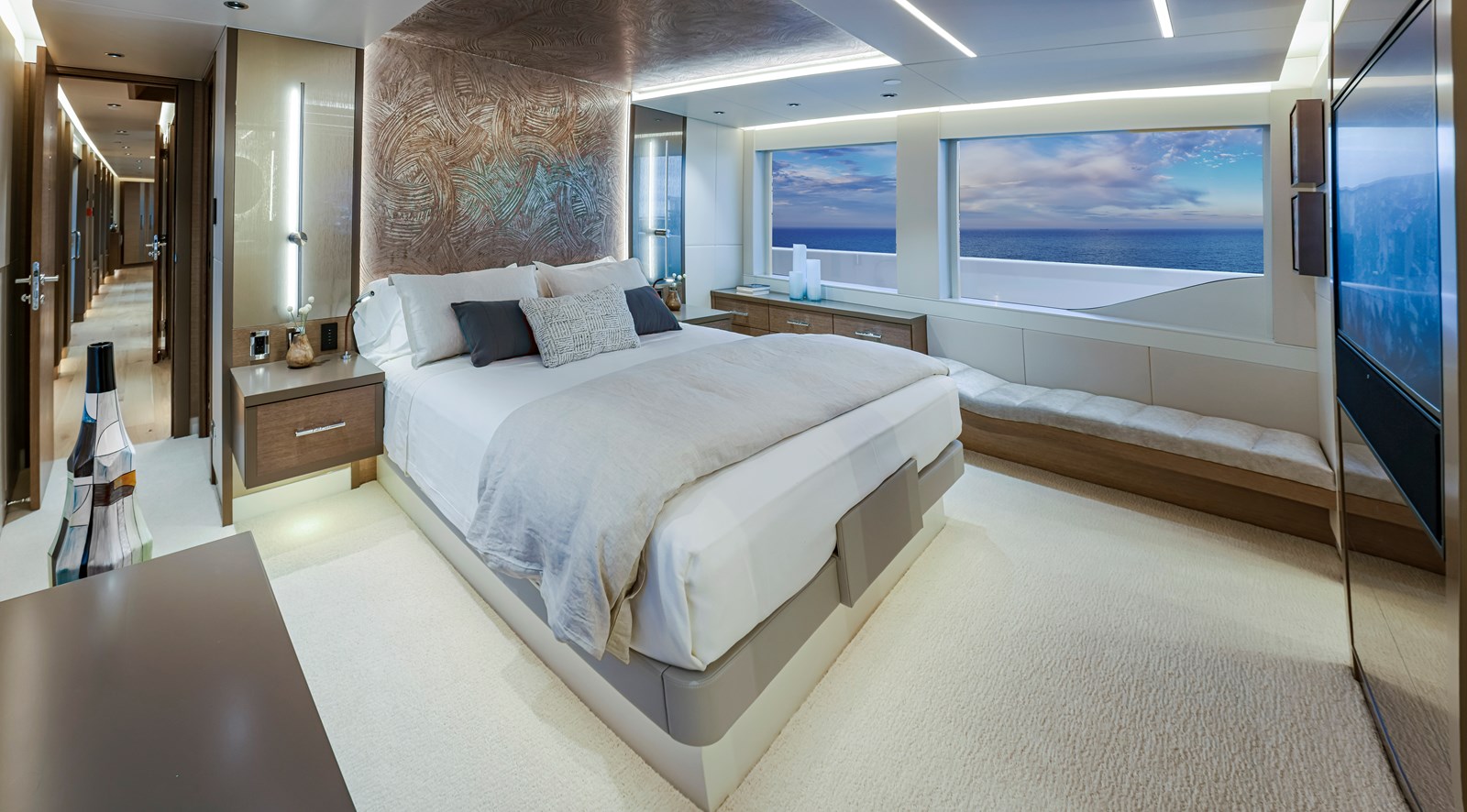 Westport W117 full-beam master stateroom with sculptural headboard and ocean view windows